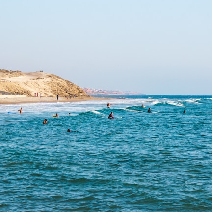 people riding surfboards in ocean at daytime