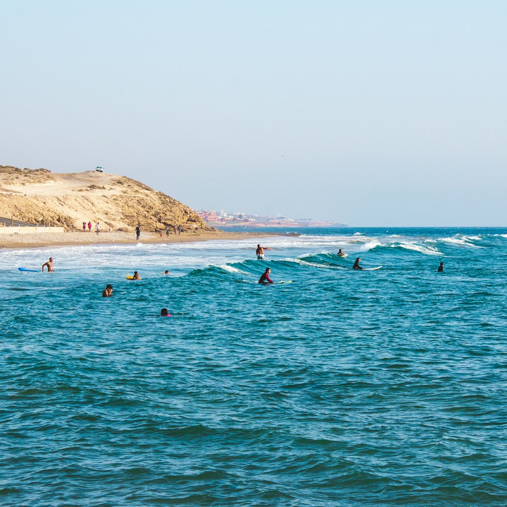 people riding surfboards in ocean at daytime