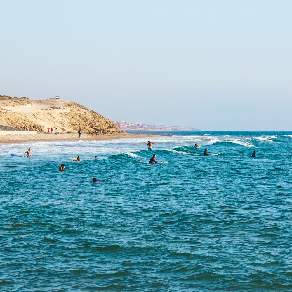 Persone che cavalcano tavole da surf nell'oceano durante il giorno