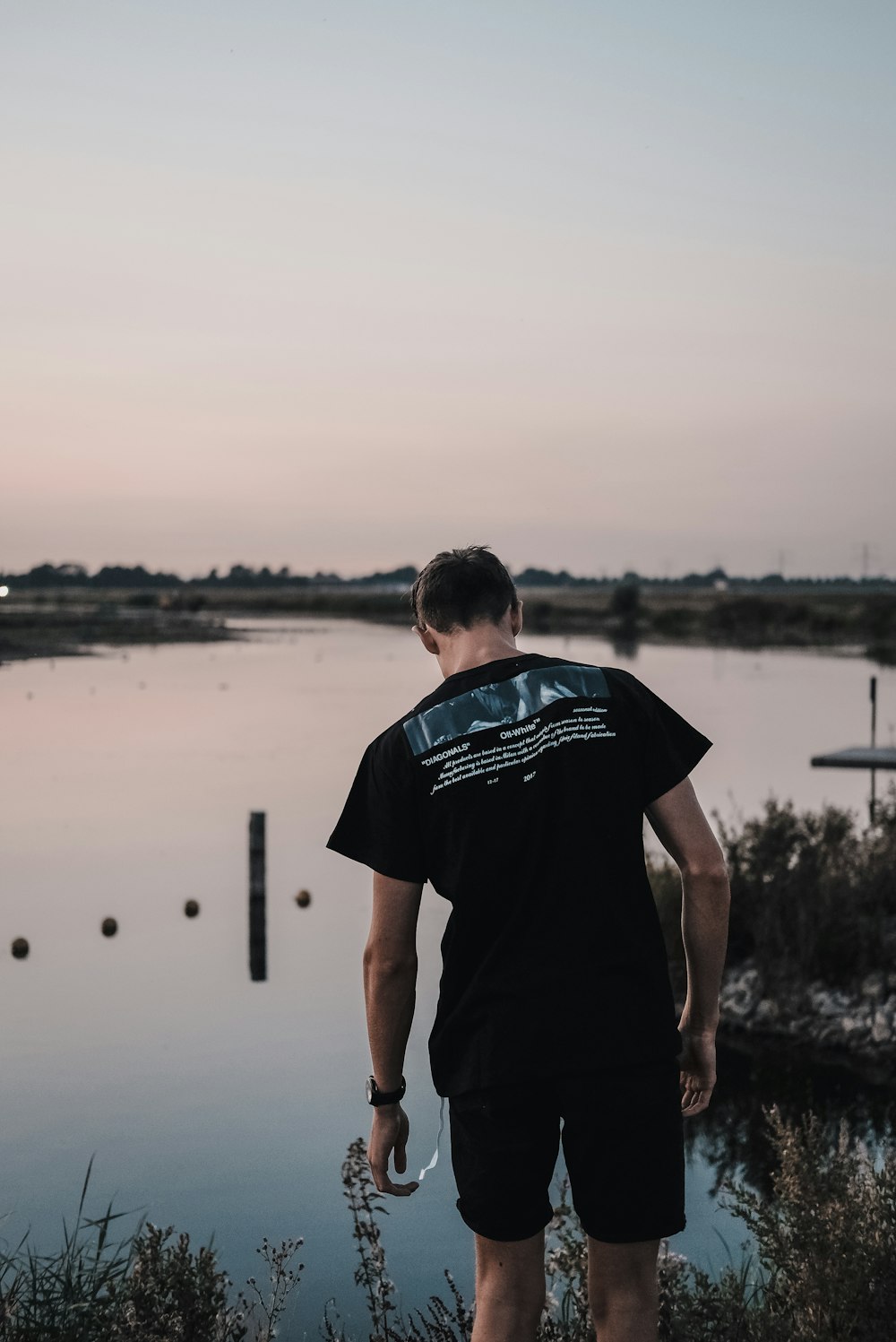 man wearing black shirt near lake