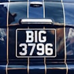 Close-up of a shiny private number plate featuring unique characters.