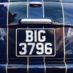 Close-up of a shiny private number plate featuring unique characters.