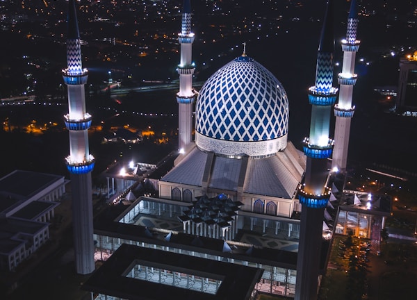 white and blue dome concrete building with 4-towers during night time