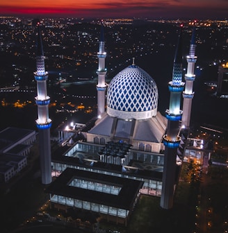 white and blue dome concrete building with 4-towers during night time