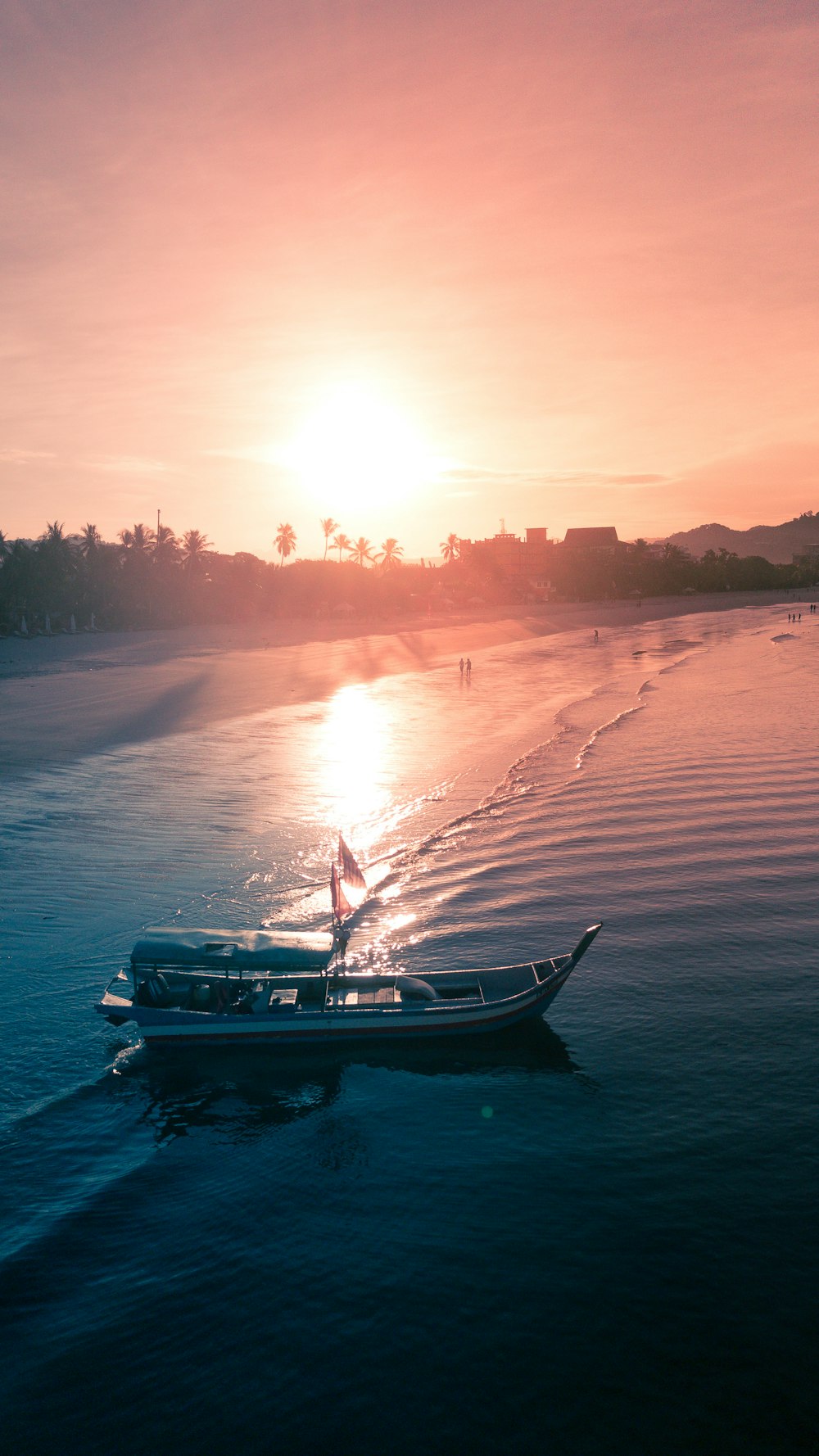 Weißes Boot am Meeresufer während des Sonnenuntergangs