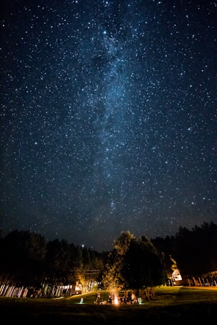 Nighttime campfire gathering with stars sparkling above the Alula desert.