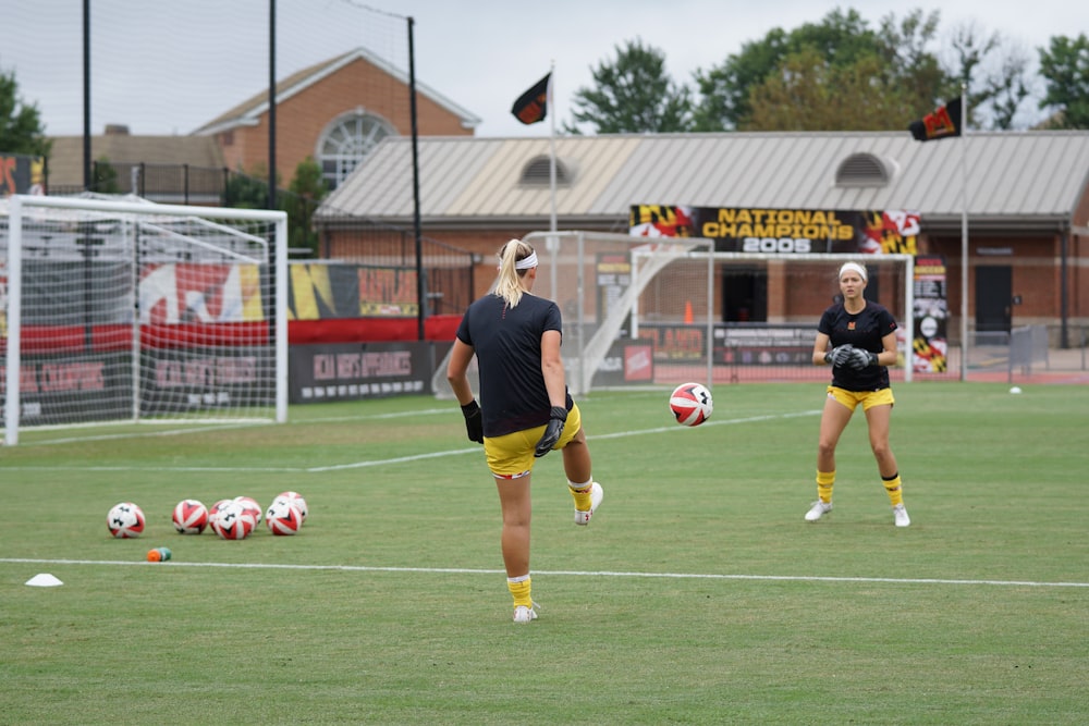 two women playing soccer on field