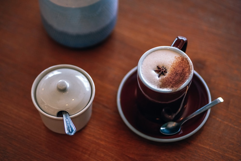 tazza da caffè su piattino accanto al contenitore