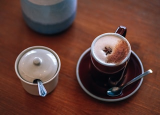 coffee mug on saucer beside canister