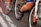 Cyclists are in close proximity, with focus on the lower body and bicycles. The image captures a busy and energetic scene likely from a race or group ride. The emphasis is on the cycling shoes, pedals, and the bicycles' frames and wheels.