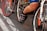 Cyclists are in close proximity, with focus on the lower body and bicycles. The image captures a busy and energetic scene likely from a race or group ride. The emphasis is on the cycling shoes, pedals, and the bicycles' frames and wheels.