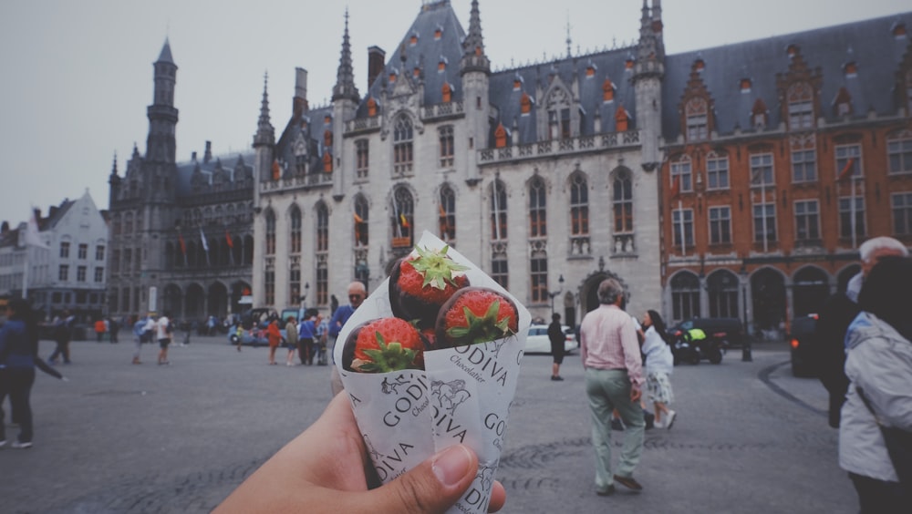 person holding pack of Godiva chocolate-covered strawberries