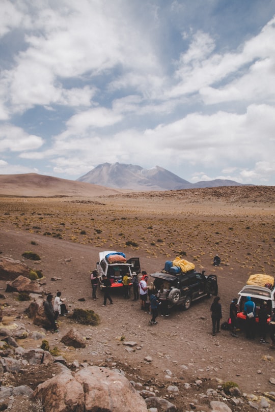 group of people standing near SUVs in Eduardo Avaroa National Reserve of Andean Fauna Bolivia