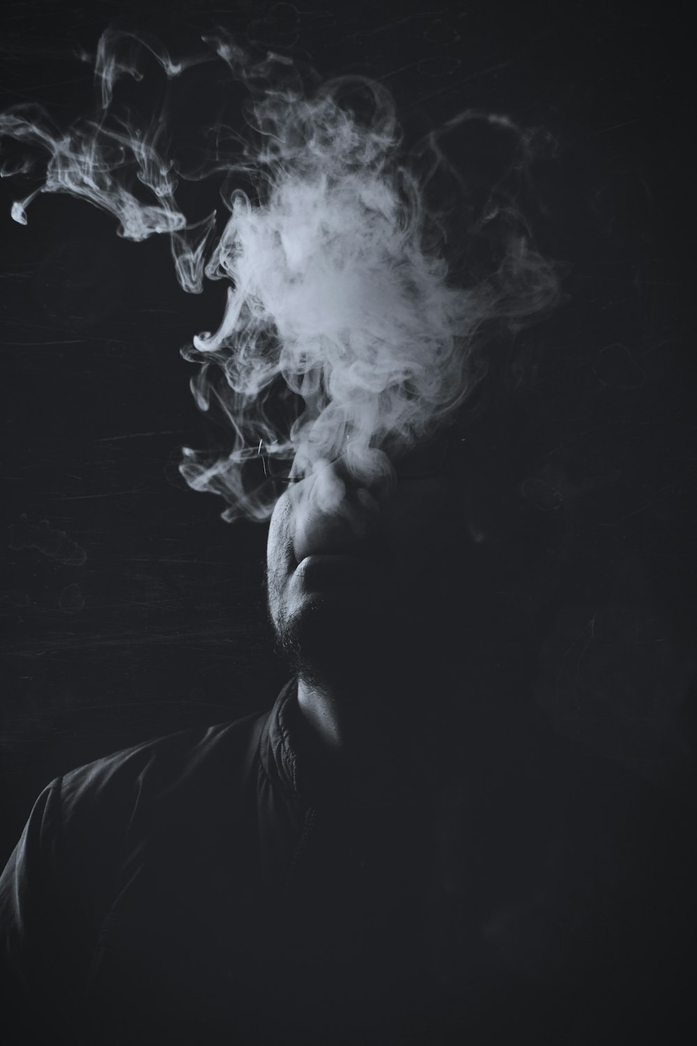 fotografia em tons de cinza do homem com fumaça