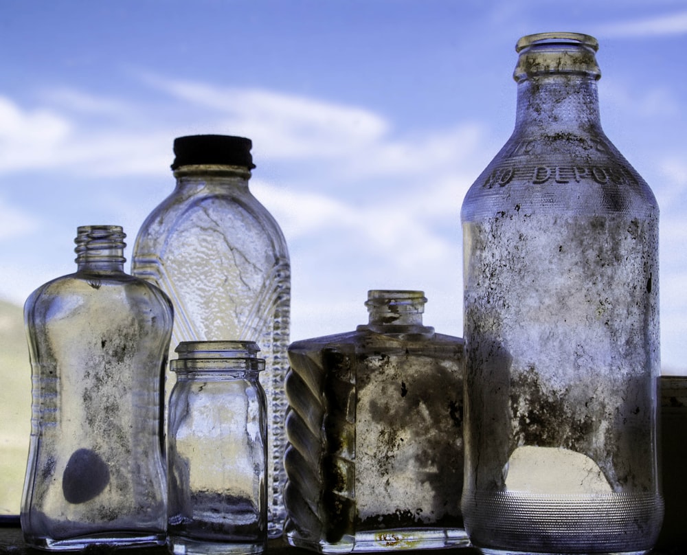 several assorted empty dirty clear glass bottles during day