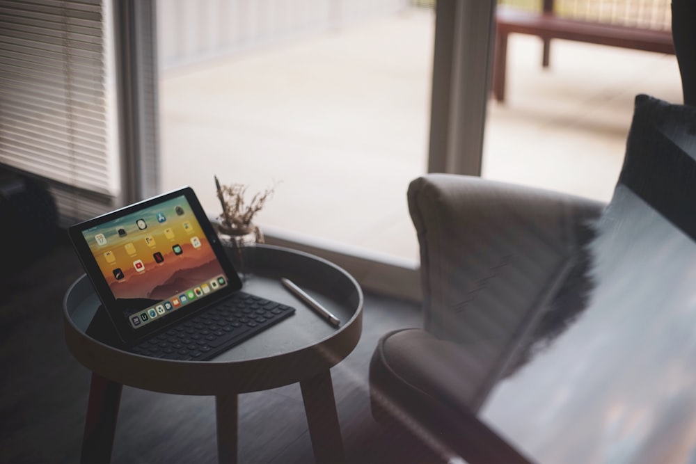 close-up photo of black iPad on brown wooden end table