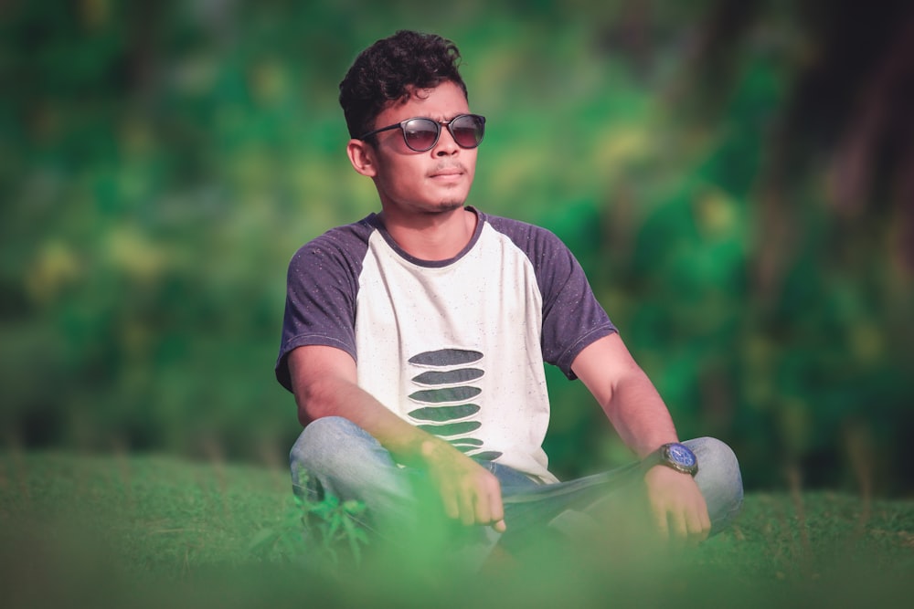 man sitting on green grass field during daytime