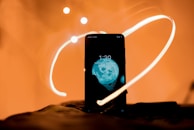 A phone case decorated with tiny hand-drawn stars and moons glowing softly in dim light.