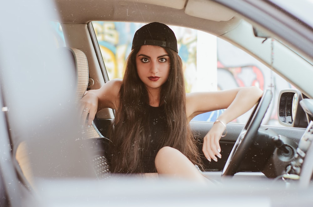 昼間、帽子をかぶって車内に座っている女性