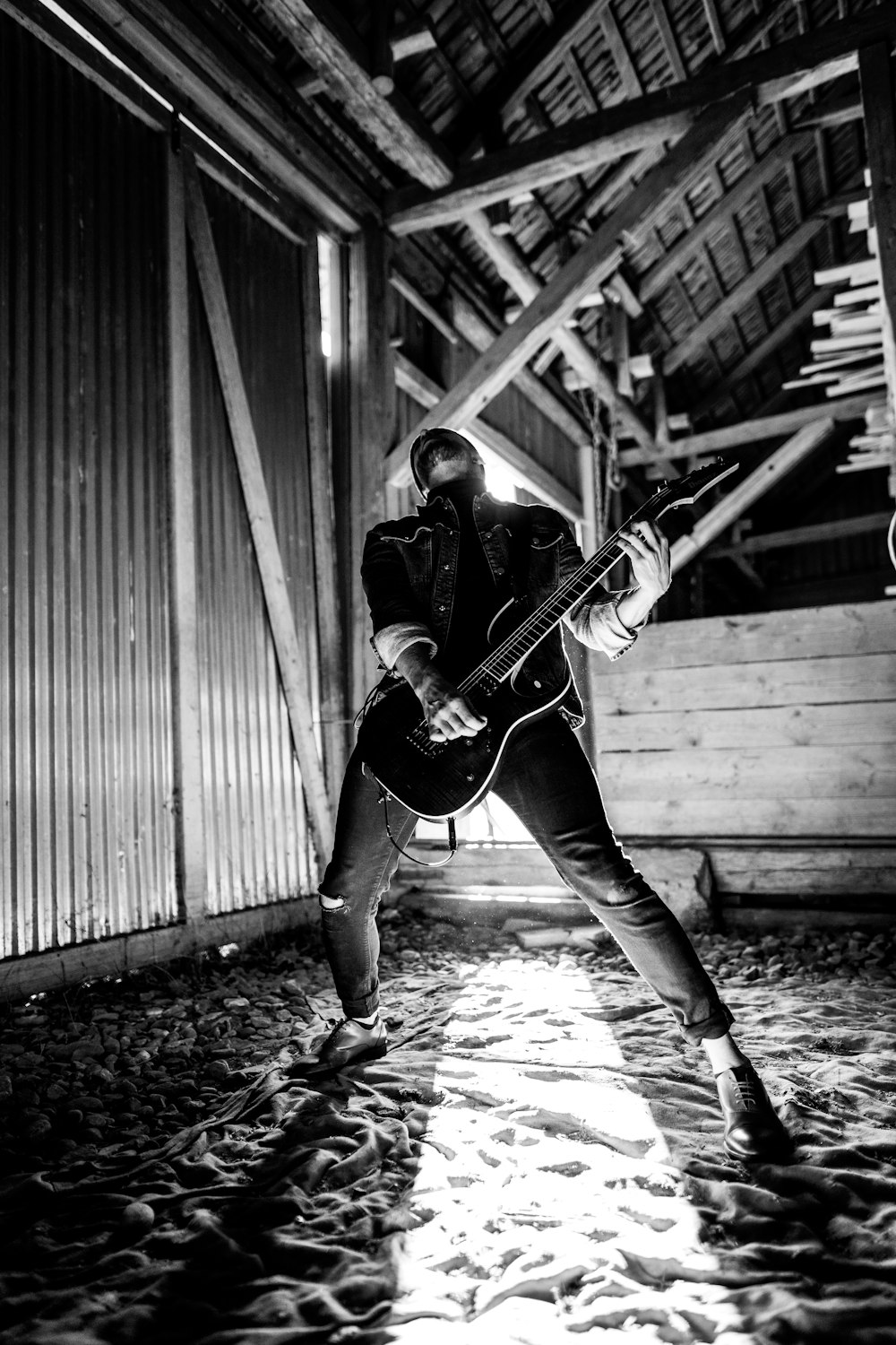 man playing electric guitar beside wall