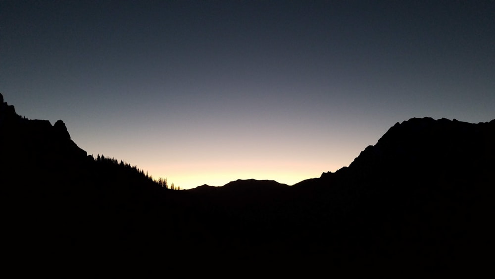 silhouette of mountain range under golden hour