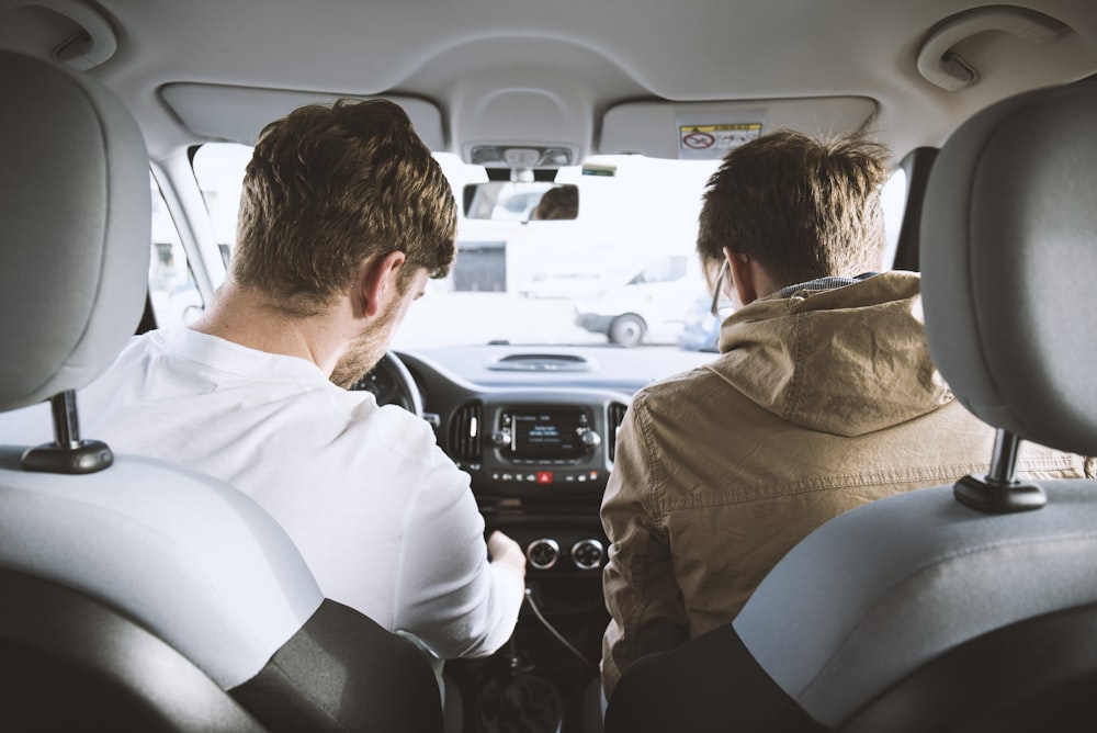 dois homens sentados dentro do veículo
