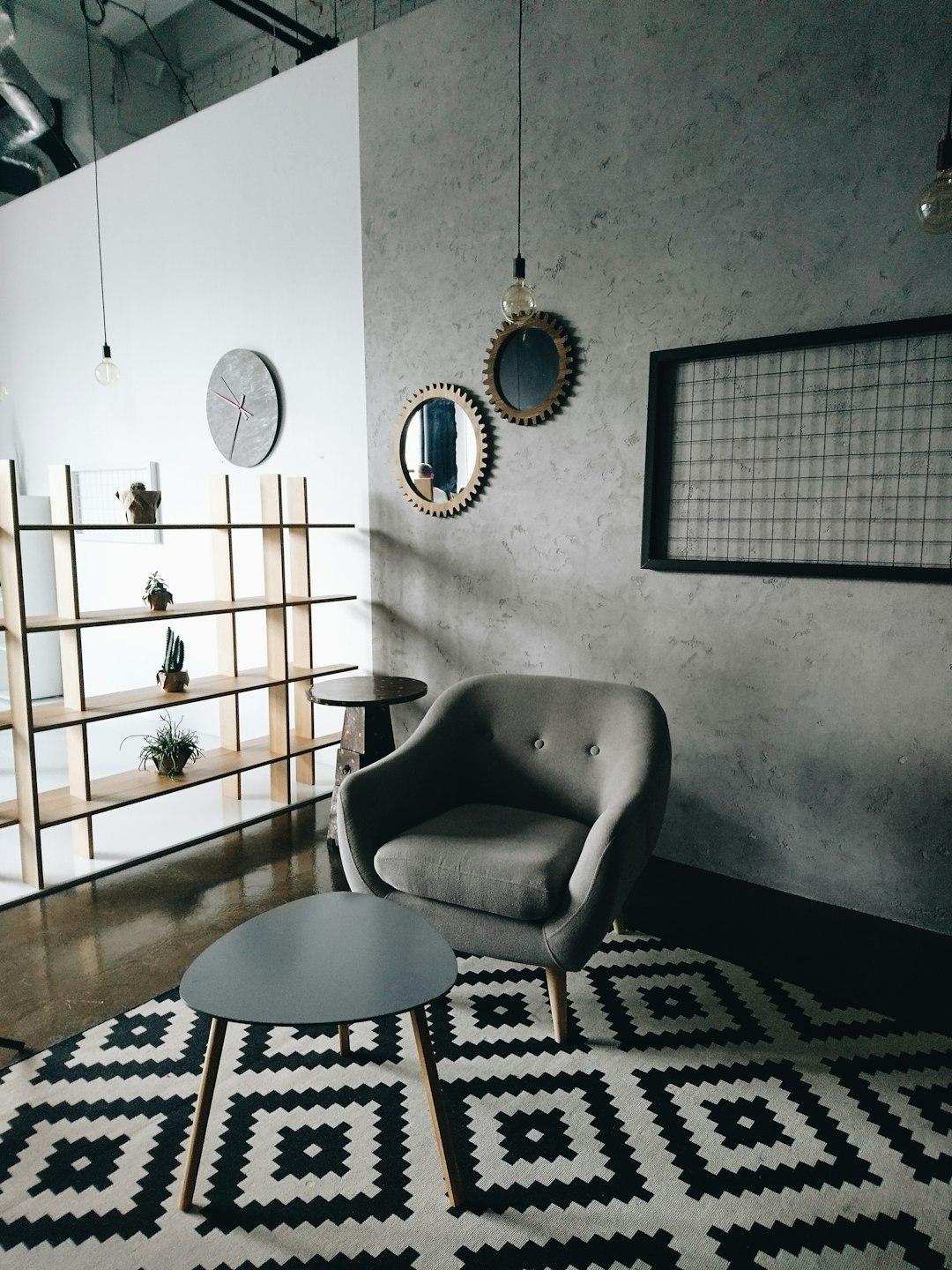  gray padded couch in front of wooden center table armchair