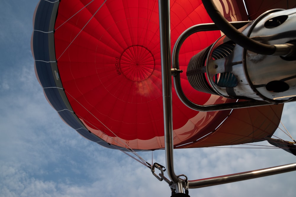 low-angle photography of red and black hot air balloon under blue and white sky