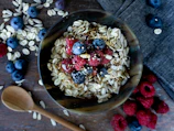 A softly lit kitchen counter with a bowl of oatmeal topped with fresh berries and a linen napkin nearby.