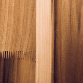 Close-up of detailed wood panel joints being fitted together by skilled hands.