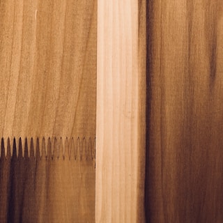 Close-up of detailed wood panel joints being fitted together by skilled hands.