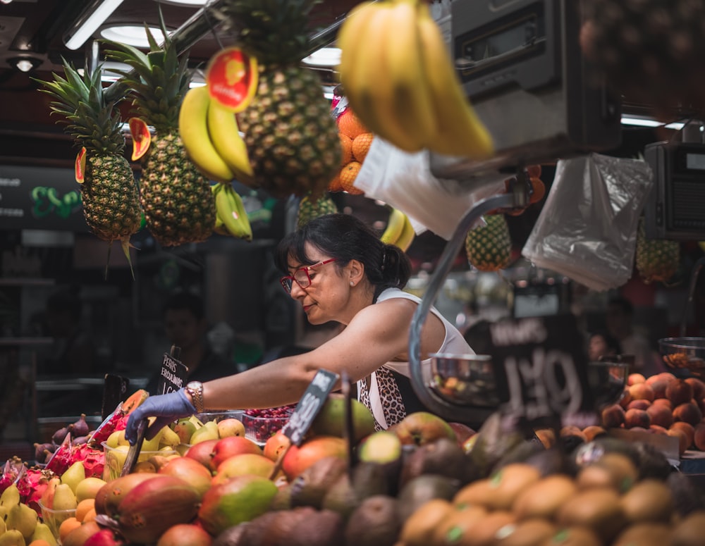 Fotografia a fuoco selettiva di una donna che vende frutta