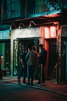 three men standing beside black wooden door