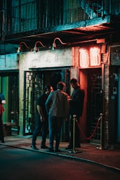 three men standing beside black wooden door