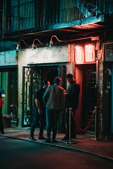 three men standing beside black wooden door