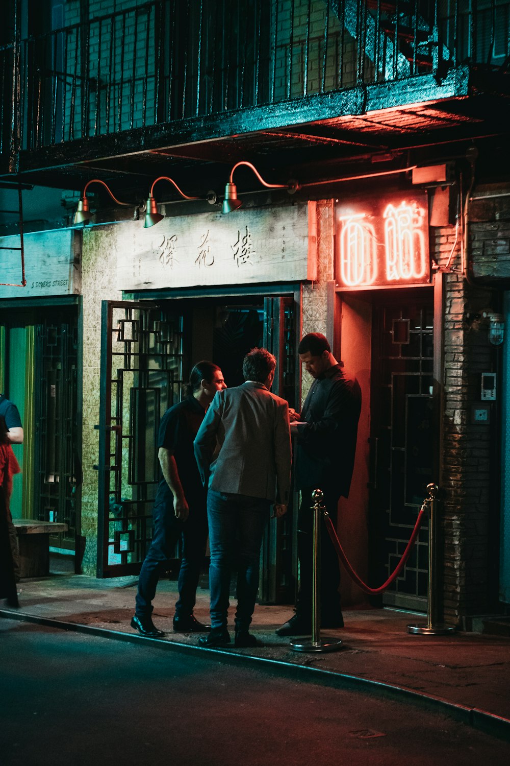 three men standing beside black wooden door