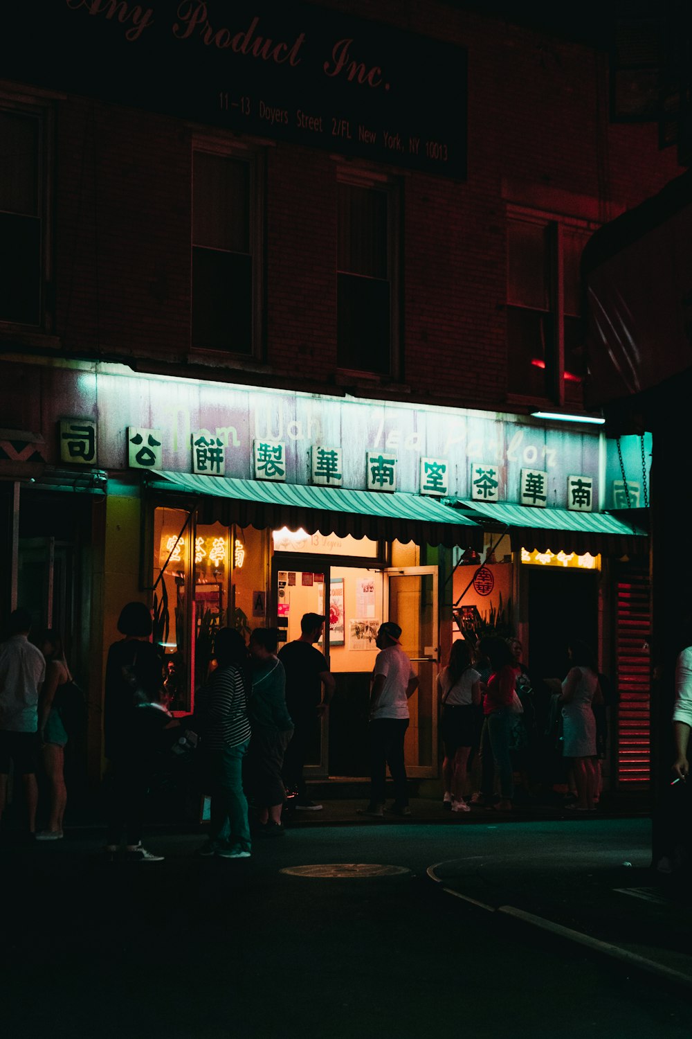 Personas de pie frente a la tienda durante la noche