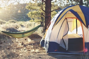white, yellow, and blue dome tent near green hammock