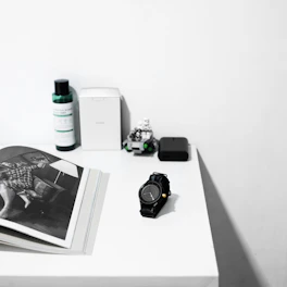 A person thoughtfully comparing two products side by side on a clean desk.