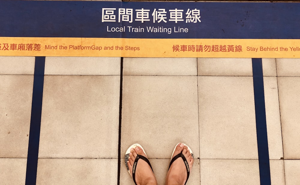person facing local train waiting line signage