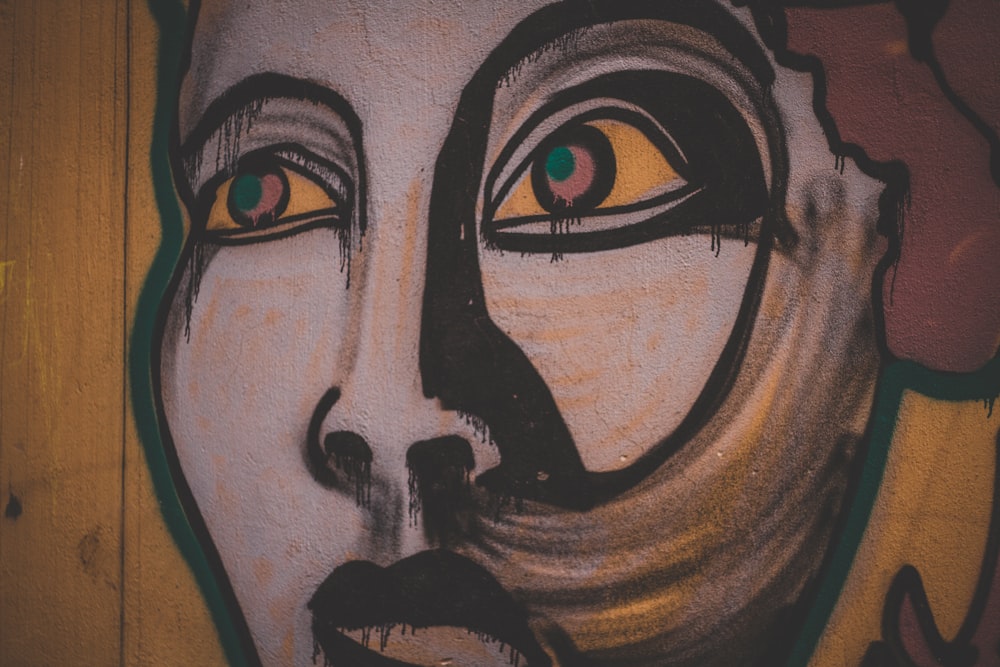 a close up of a face painted on a wall