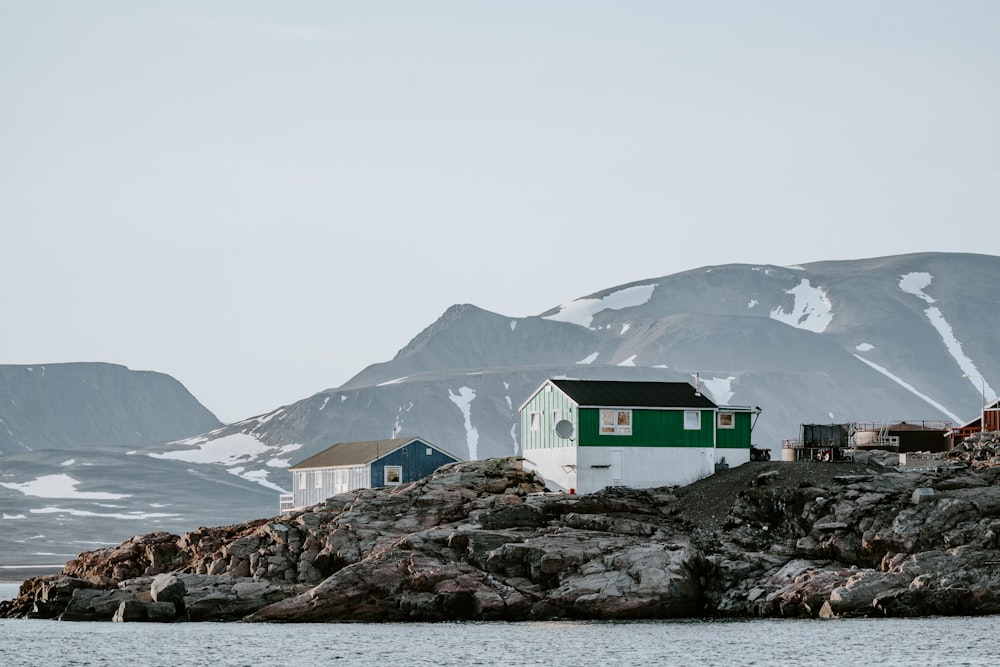 white and green wooden house near body of water