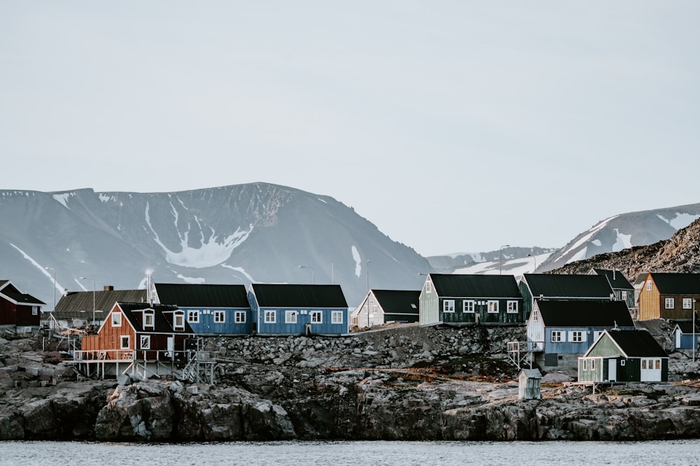 houses near mountain and body of water