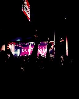 A lively community event with people enjoying music, food, and Bud of the Year banners.