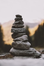 Close-up of stacked stones symbolizing balance and stability against a blurred natural background.