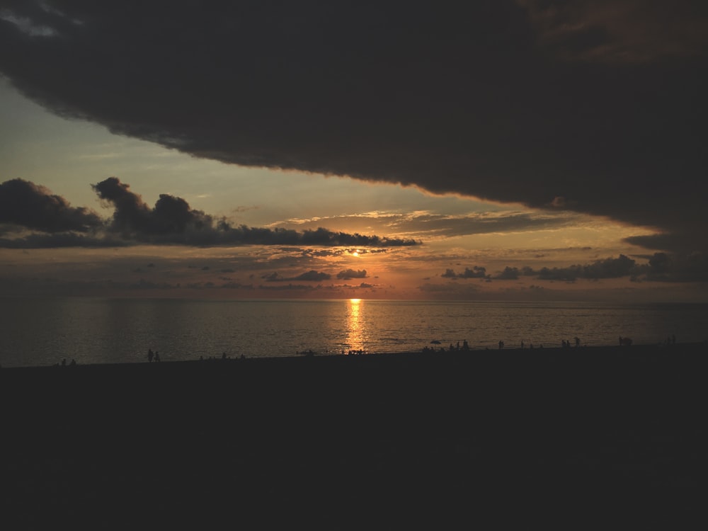 silhouette photo of body of water during sunset