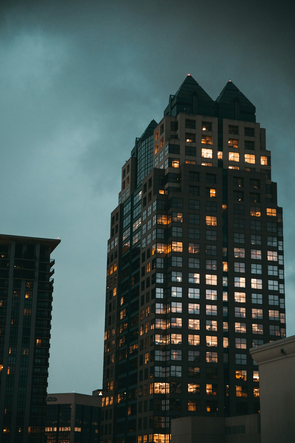 black glass-panel building under dark clouds