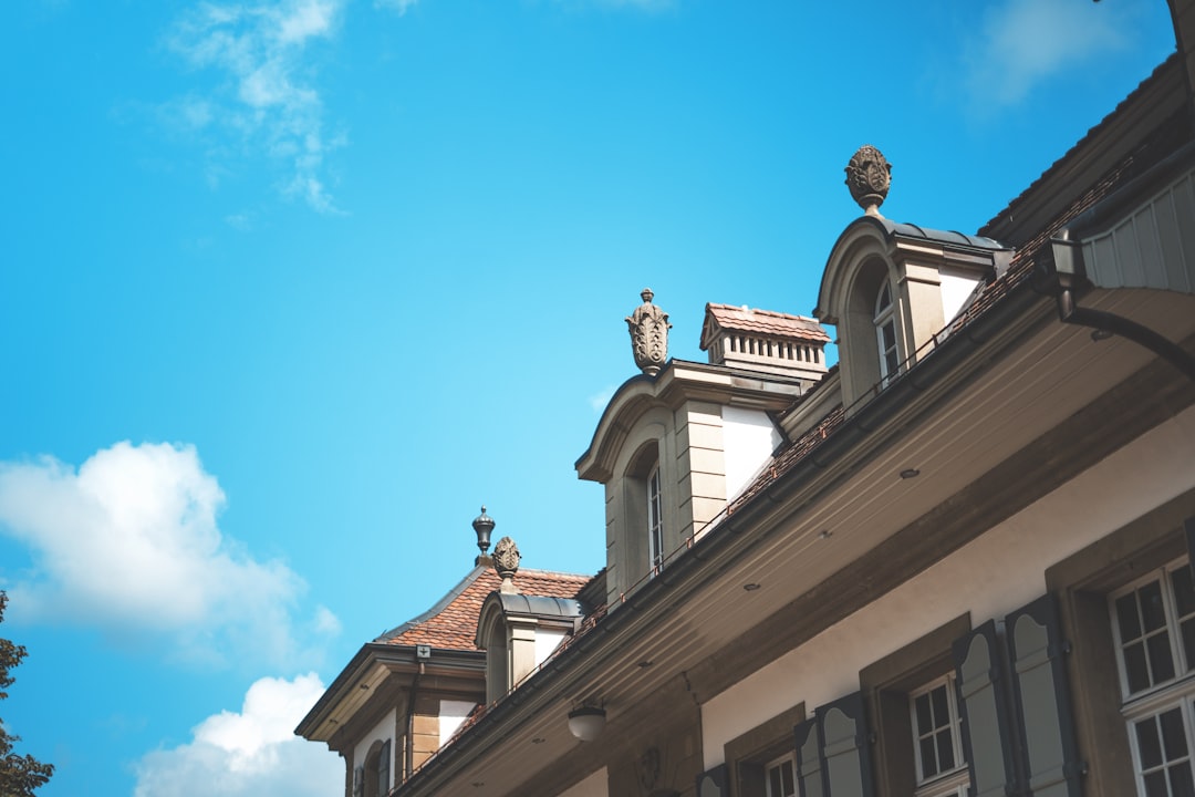 white and brown concrete house under blue and white skies