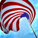 A waving American flag against a bright blue sky symbolizing patriotism.