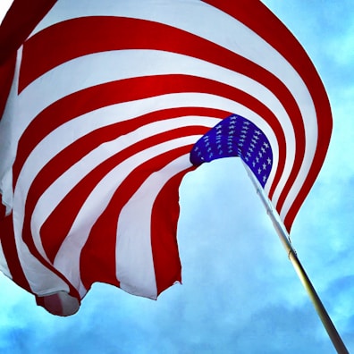 A waving American flag against a bright blue sky symbolizing patriotism.